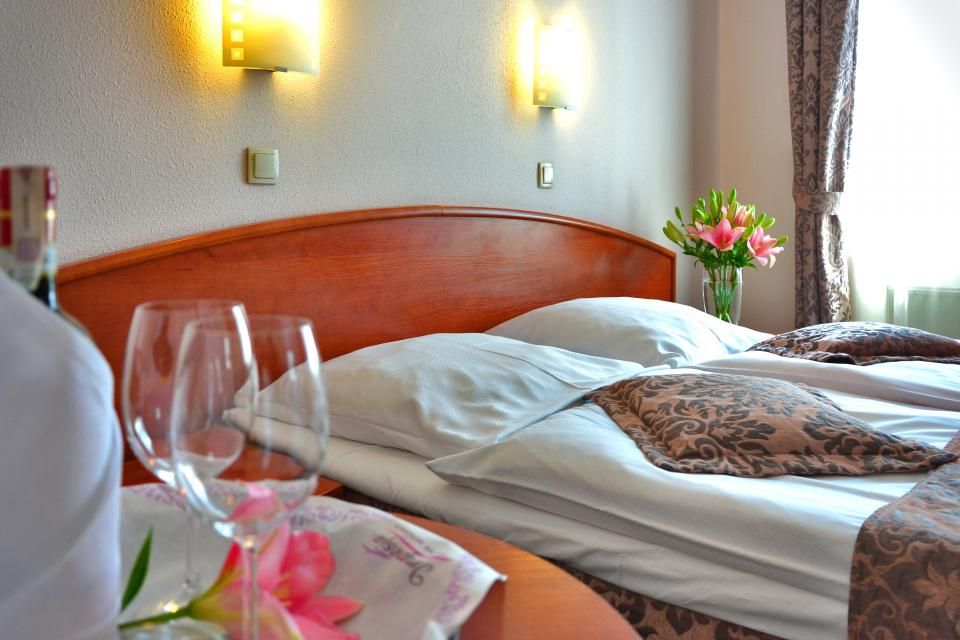 A guest room with a large bed and soft lighting